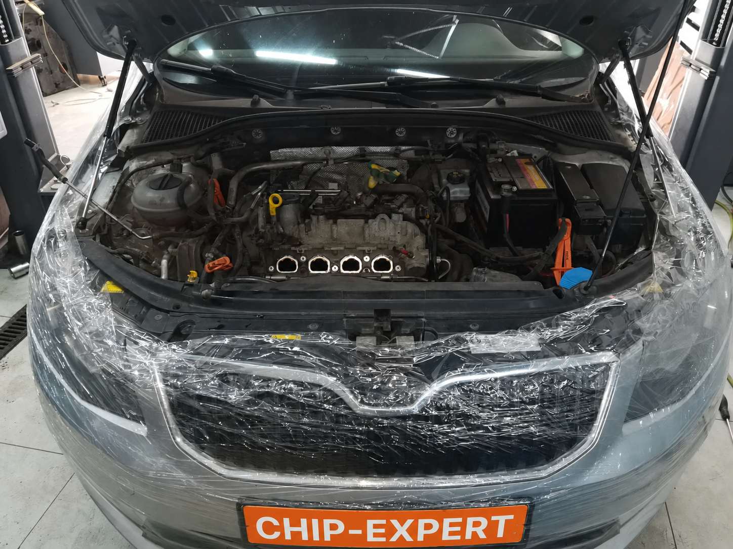В моторном отсеке Skoda Octavia III Combi 1.4 TSI 2014 снят впускной коллектор и открыт доступ к четырём впускным каналам для орехоструйной чистки в мастерской «Чип-Эксперт» — chip-expert.pro.