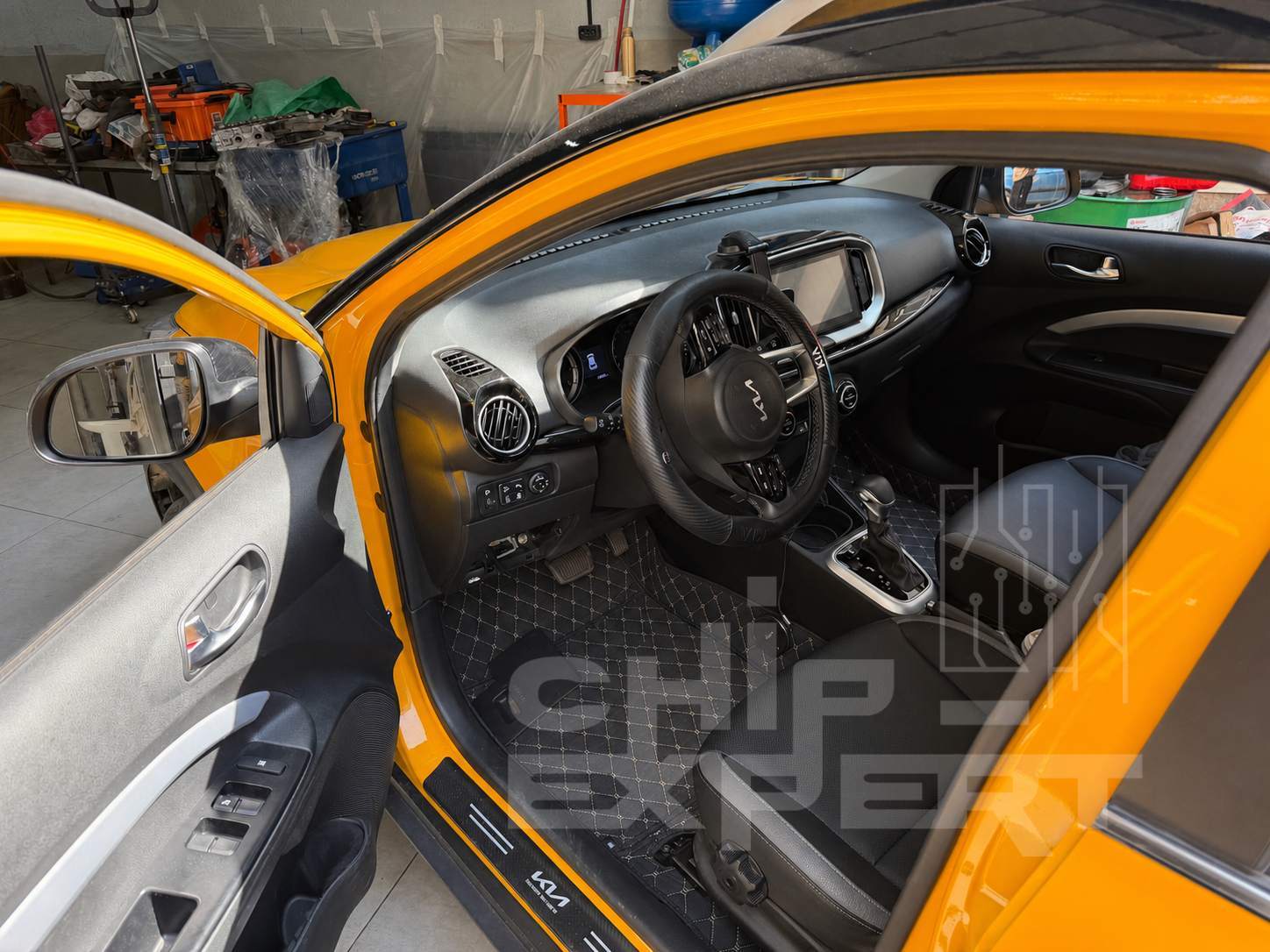 Салон Kia KX1 (QE) 1.4 2022 со стороны водителя во время прошивки через диагностический разъём в мастерской Чип-Эксперт — chip-expert.pro.